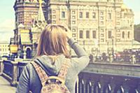 Young woman backpacker takes a picture of Church o